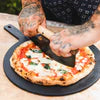 Pizza rocker knife with curved stainless blade and wooden handle on pizza