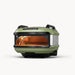 Green portable outdoor oven with glowing wood-fired interior and dark metal handles