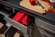 Black outdoor kitchen island with red interior drawers and stainless steel handles, modular design