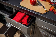 Black outdoor kitchen island with red interior drawers and stainless steel handles, modular design